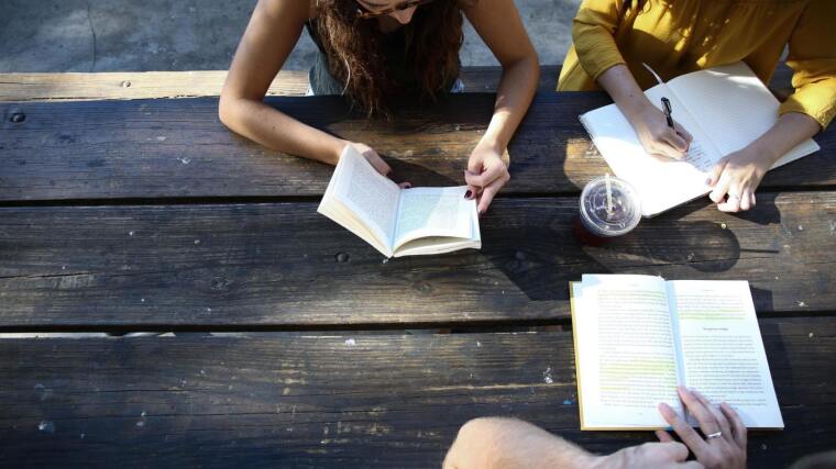 Students reading texts together at a table
